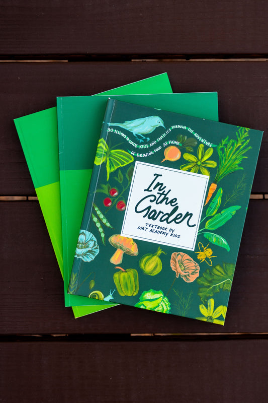 Three green notebooks with garden-themed designs on a wooden surface